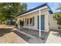 Inviting front porch featuring white chairs, complemented by blue shutters and door, creating a welcoming entrance at 2720 Trinidad St, Sarasota, FL 34231
