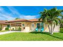Beautiful home with a terracotta roof, a covered carport, and inviting blue Adirondack chairs on the front porch at 3213 Cambridge Ave, Bradenton, FL 34207