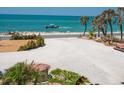 Gravel driveway with palm trees leading to a coastal home near the beach at 3300 Casey Key Rd, Nokomis, FL 34275