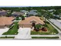 Inviting single-Gathering home featuring a spacious driveway, well-manicured lawn, and lush landscaping in quiet neighborhood at 4706 Josselin Pl, Parrish, FL 34219