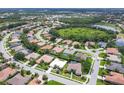 An aerial view showcases a community with lush greenery and a serene lake in the background at 5106 Far Oak Cir, Sarasota, FL 34238