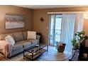 Comfortable living room featuring a plush sofa, glass coffee table, and sliding glass doors at 5400 26Th W St # F104, Bradenton, FL 34207