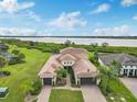 Beautiful waterfront home with a spacious lawn, lush landscaping, and a three-car garage at 5402 Tidewater Preserve Blvd, Bradenton, FL 34208