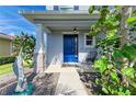 Inviting front porch with a bright blue door and decorative fish statue at 6125 35Th E Ct, Bradenton, FL 34203