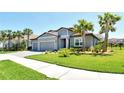 Inviting home with a neatly kept lawn, three-car garage, and swaying palm trees that enhance its curb appeal at 6800 Dunlin Ct, Sarasota, FL 34241