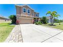 Exterior elevation of a tan two-story home with a well-manicured lawn and a long, spacious driveway at 7822 110Th E Ave, Parrish, FL 34219