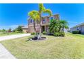 The front yard features a well-manicured lawn, lush landscaping, and a long driveway leading up to a two-car garage at 7822 110Th E Ave, Parrish, FL 34219