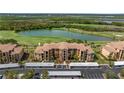 Beautiful aerial view of the condo building overlooking a scenic lake and golf course at 8205 Grand Estuary Trl # 101, Bradenton, FL 34212