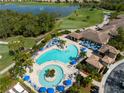 Aerial view of a stunning community pool and lounge area with lush landscaping and nearby golf course at 8205 Grand Estuary Trl # 101, Bradenton, FL 34212