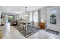 Bright dining area featuring a large island table, stylish decor, and an open floor plan leading to the outdoor patio at 12291 Myrtle Bay Ct, Sarasota, FL 34238