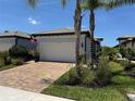 Charming single-Gathering home featuring a brick driveway, two car garage, and a well manicured lawn and garden at 12291 Myrtle Bay Ct, Sarasota, FL 34238