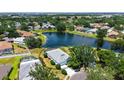 Attractive aerial view presenting a house near a tranquil lake in a community dotted with lush trees at 12339 Hollybush Ter, Lakewood Ranch, FL 34202