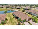 Beautiful aerial view of property showcasing tile roof, pond, landscaping, and community at 12640 Felice Dr, Venice, FL 34293