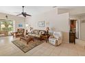 Open-concept living room with tile floors, a ceiling fan, and comfortable seating at 128 Braemar Ave, Venice, FL 34293