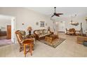 Bright living room featuring tile flooring, a ceiling fan, and comfortable rattan furniture at 128 Braemar Ave, Venice, FL 34293