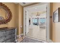 Elegant foyer with decorative mirror, dresser, leading to a living room with stunning water views at 130 Riviera Dunes Way # 903, Palmetto, FL 34221
