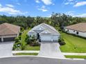 Aerial view of a light blue home featuring a lush lawn and a 2 car attached garage at 13319 Deep Blue Pl, Bradenton, FL 34211