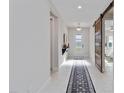 Bright hallway with light tile, a sliding barn door, and a decorative runner at 16148 Preservation Blvd, Punta Gorda, FL 33982