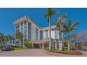 Striking building exterior featuring an elegant entrance, lush landscaping, and beautiful brick driveways at 1701 Gulf Of Mexico Dr # 502, Longboat Key, FL 34228