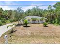 Spacious home exterior with well-maintained lawn and mature trees at 1709 Kerman St, North Port, FL 34288