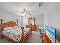 Bright bedroom featuring a ceiling fan, a large wooden bed frame, and plenty of natural light at 1723 Fred Ives St, Ruskin, FL 33570