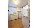 Galley kitchen with stainless steel refrigerator and white appliances and cabinetry at 1819 Restful Dr # N25, Bradenton, FL 34207