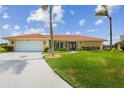 Inviting home featuring a manicured lawn and a spacious driveway leading to a two-car garage at 1836 Ironwood Ct, Venice, FL 34293