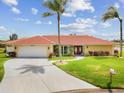 Charming home featuring a well-manicured lawn and a spacious driveway leading to a two-car garage at 1836 Ironwood Ct, Venice, FL 34293