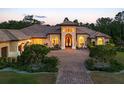Elegant home exterior boasts an arched entry, lush landscaping, and a terracotta tiled roof at 20706 79Th E Ave, Bradenton, FL 34202