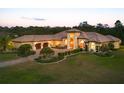 Aerial view of a sprawling estate home with a terracotta roof, mature landscaping, and an attached garage at 20706 79Th E Ave, Bradenton, FL 34202