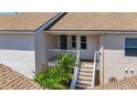 Close up view of the townhome entrance, with stairway, landing, and tropical landscaping at 2609 Waterford Way # B, Palmetto, FL 34221