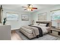 Bright bedroom features a ceiling fan, hardwood floors, two windows, and artwork that adds to the room's charm at 2705 20Th Avenue W Dr, Bradenton, FL 34205