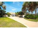Well-manicured front yard with lush lawn, palm trees and a circular driveway at 3201 Wilderness W Blvd, Parrish, FL 34219