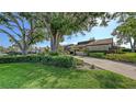 This property features a lush green lawn, mature trees, and meticulously manicured shrubs, enhancing its curb appeal at 3608 Avenida Madera, Bradenton, FL 34210