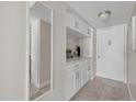 Inviting hallway featuring custom built-ins, stylish mirror, and neutral color palette at 3806 Gulf Of Mexico Dr # C311, Longboat Key, FL 34228