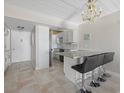 Kitchen with breakfast bar seating, modern appliances, and stylish chandelier at 3806 Gulf Of Mexico Dr # C311, Longboat Key, FL 34228