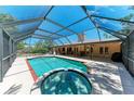 Backyard pool with a screened enclosure, spa, and patio area, perfect for outdoor relaxation and entertainment at 410 136Th E Ct, Bradenton, FL 34212