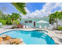 Refreshing kidney-shaped pool with waterfall feature and white lounge chairs at 410 Garfield Dr, Sarasota, FL 34236