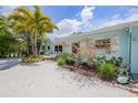 Well-maintained home exterior with lush landscaping and a bright blue facade at 410 Garfield Dr, Sarasota, FL 34236
