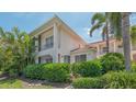 Well-maintained condo exterior featuring lush greenery, a private balcony, and a red tile roof at 4264 Central Sarasota Pkwy # 111, Sarasota, FL 34238