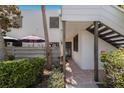 A bright condo exterior featuring a private patio, staircase, and verdant greenery at 536 Lakeside Dr # 0, Bradenton, FL 34210