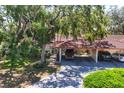 Charming home featuring a carport and a lush, mature landscape that offers natural shade and beauty at 6304 Pelican Dr, Bradenton, FL 34210