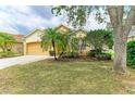 Landscaped lawn of single-story house, with attached 2-car garage and beautiful green trees at 6546 Blue Grosbeak Cir, Lakewood Ranch, FL 34202