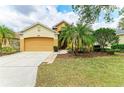 Well-manicured lawn of a single-story house, with an attached 2-car garage and brick-lined walkway at 6546 Blue Grosbeak Cir, Lakewood Ranch, FL 34202
