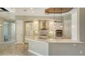 Bright kitchen featuring white cabinets, stainless steel appliances, a large island, and a stylish range hood at 6931 Brier Creek Ct, Lakewood Ranch, FL 34202
