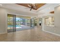 Spacious living room with tile flooring, a wood-paneled ceiling, and sliding glass doors to a screened-in pool area at 6931 Brier Creek Ct, Lakewood Ranch, FL 34202