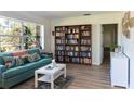 Comfortable living room with a teal sofa, built-in bookshelves, and large bright window at 91 39Th Street Nw Ct, Bradenton, FL 34205