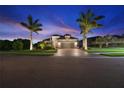 Beautiful home exterior at dusk with palm trees and a brick driveway, showcasing curb appeal at 9774 Highland Park Pl, Palmetto, FL 34221