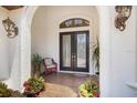 Inviting front entryway with decorative double doors, brick landing, and decorative sconces at 11447 Savannah Lakes Dr, Parrish, FL 34219