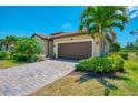 Single Gathering home with a 2-car garage, tile roof, manicured landscaping, and a paver driveway at 12315 Canavese Ln, Venice, FL 34293